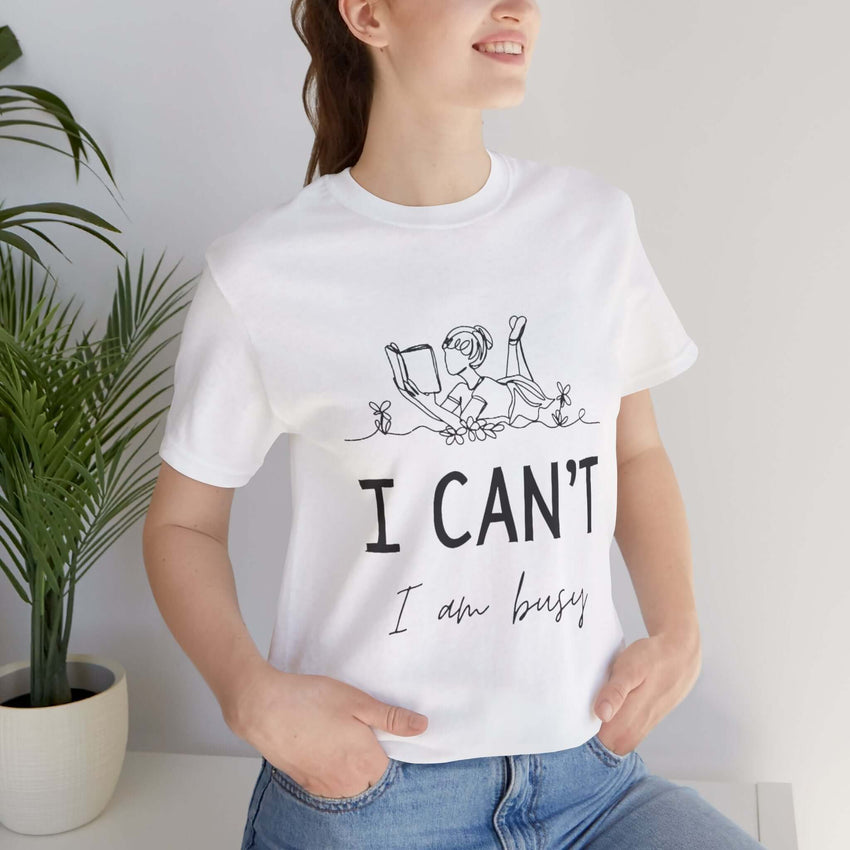 I Can’t, I’m Busy Unisex Jersey Short Sleeve TeeShow off your love for quiet moments with our I Can’t, I’m Busy Unisex Jersey Short Sleeve Tee. Perfect for book lovers and those who cherish their downtime, this tee features a playful illustration of a per