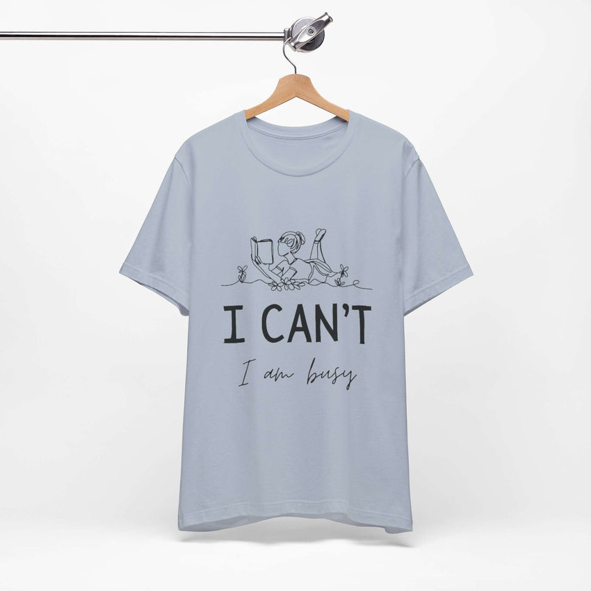 I Can’t, I’m Busy Unisex Jersey Short Sleeve TeeShow off your love for quiet moments with our I Can’t, I’m Busy Unisex Jersey Short Sleeve Tee. Perfect for book lovers and those who cherish their downtime, this tee features a playful illustration of a per