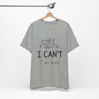 I Can’t, I’m Busy Unisex Jersey Short Sleeve TeeShow off your love for quiet moments with our I Can’t, I’m Busy Unisex Jersey Short Sleeve Tee. Perfect for book lovers and those who cherish their downtime, this tee features a playful illustration of a per