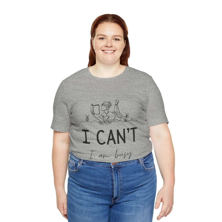 I Can’t, I’m Busy Unisex Jersey Short Sleeve TeeShow off your love for quiet moments with our I Can’t, I’m Busy Unisex Jersey Short Sleeve Tee. Perfect for book lovers and those who cherish their downtime, this tee features a playful illustration of a per