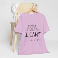 I Can’t, I’m Busy Unisex Jersey Short Sleeve TeeShow off your love for quiet moments with our I Can’t, I’m Busy Unisex Jersey Short Sleeve Tee. Perfect for book lovers and those who cherish their downtime, this tee features a playful illustration of a per