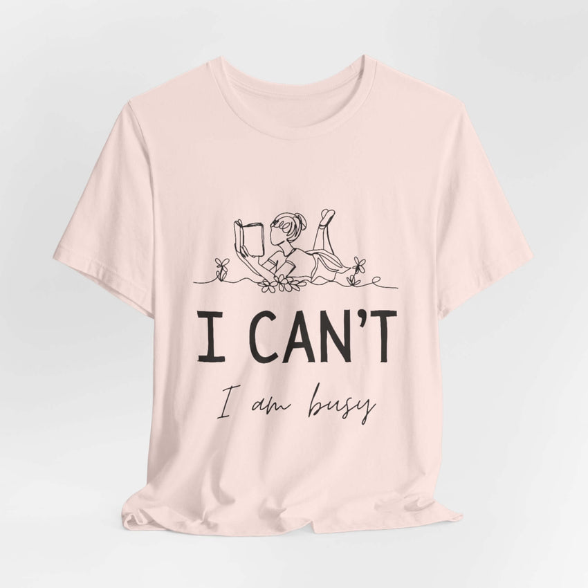 I Can’t, I’m Busy Unisex Jersey Short Sleeve TeeShow off your love for quiet moments with our I Can’t, I’m Busy Unisex Jersey Short Sleeve Tee. Perfect for book lovers and those who cherish their downtime, this tee features a playful illustration of a per