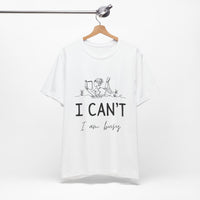 I Can’t, I’m Busy Unisex Jersey Short Sleeve TeeShow off your love for quiet moments with our I Can’t, I’m Busy Unisex Jersey Short Sleeve Tee. Perfect for book lovers and those who cherish their downtime, this tee features a playful illustration of a per