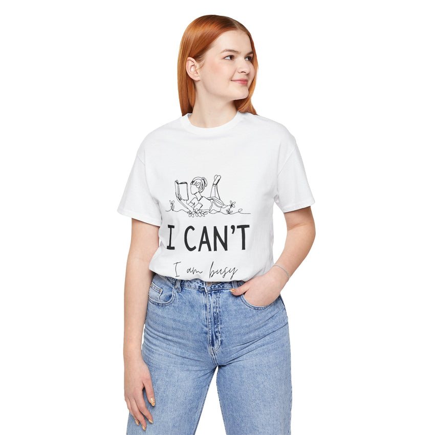 I Can’t, I’m Busy Unisex Jersey Short Sleeve TeeShow off your love for quiet moments with our I Can’t, I’m Busy Unisex Jersey Short Sleeve Tee. Perfect for book lovers and those who cherish their downtime, this tee features a playful illustration of a per