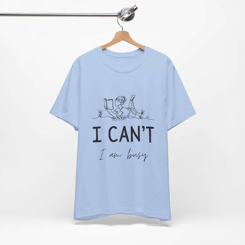 I Can’t, I’m Busy Unisex Jersey Short Sleeve TeeShow off your love for quiet moments with our I Can’t, I’m Busy Unisex Jersey Short Sleeve Tee. Perfect for book lovers and those who cherish their downtime, this tee features a playful illustration of a per