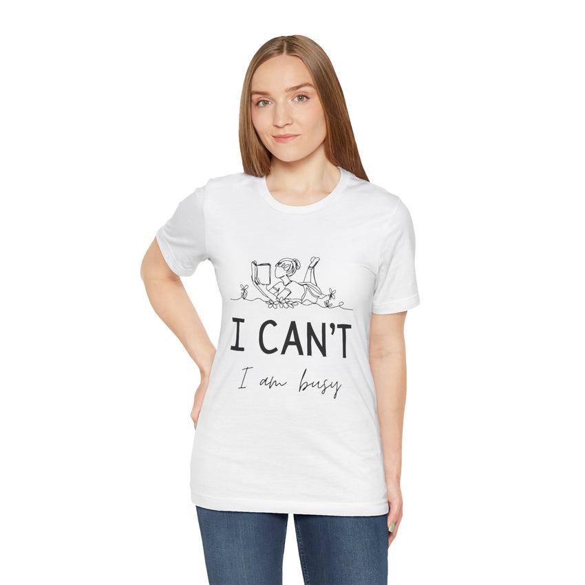 I Can’t, I’m Busy Unisex Jersey Short Sleeve TeeShow off your love for quiet moments with our I Can’t, I’m Busy Unisex Jersey Short Sleeve Tee. Perfect for book lovers and those who cherish their downtime, this tee features a playful illustration of a per