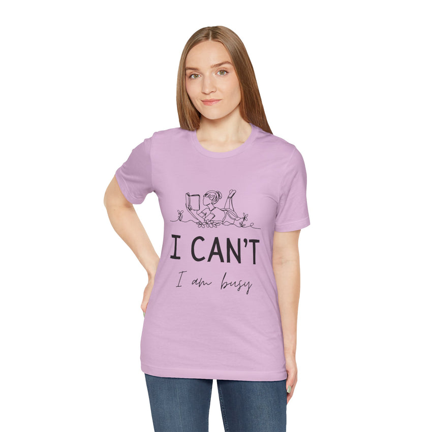 I Can’t, I’m Busy Unisex Jersey Short Sleeve TeeShow off your love for quiet moments with our I Can’t, I’m Busy Unisex Jersey Short Sleeve Tee. Perfect for book lovers and those who cherish their downtime, this tee features a playful illustration of a per