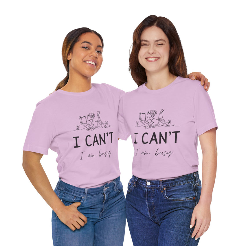 I Can’t, I’m Busy Unisex Jersey Short Sleeve TeeShow off your love for quiet moments with our I Can’t, I’m Busy Unisex Jersey Short Sleeve Tee. Perfect for book lovers and those who cherish their downtime, this tee features a playful illustration of a per