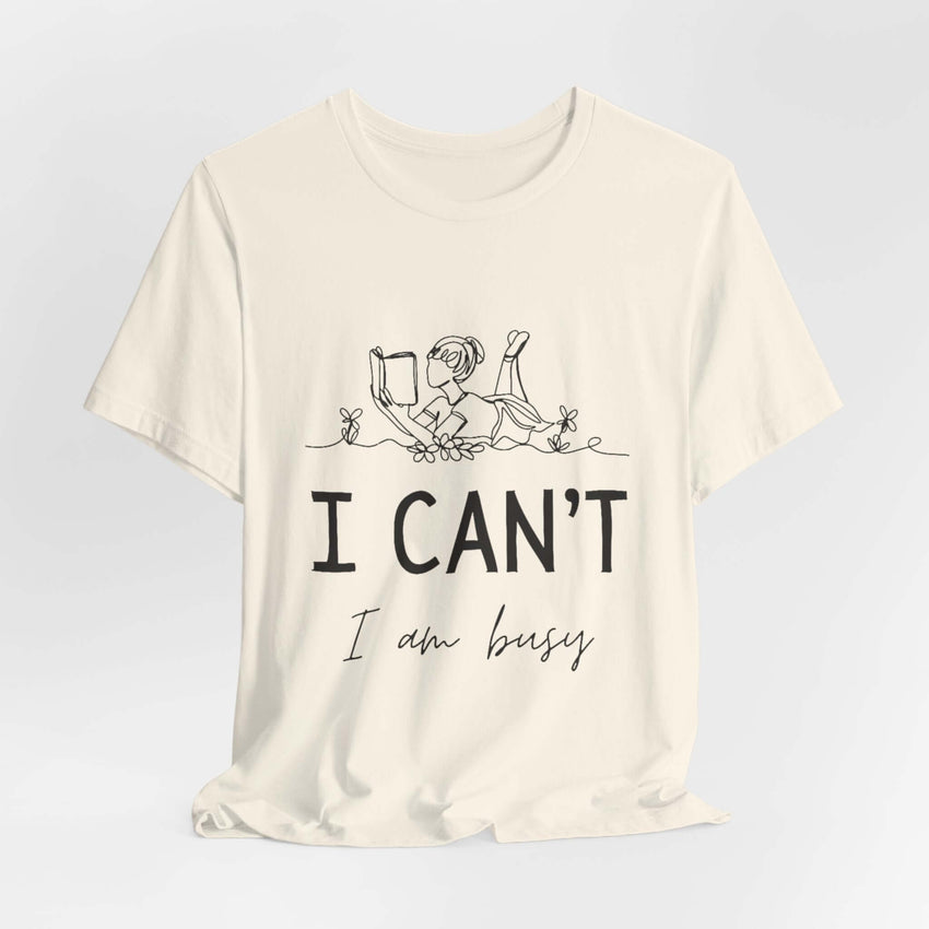 I Can’t, I’m Busy Unisex Jersey Short Sleeve TeeShow off your love for quiet moments with our I Can’t, I’m Busy Unisex Jersey Short Sleeve Tee. Perfect for book lovers and those who cherish their downtime, this tee features a playful illustration of a per