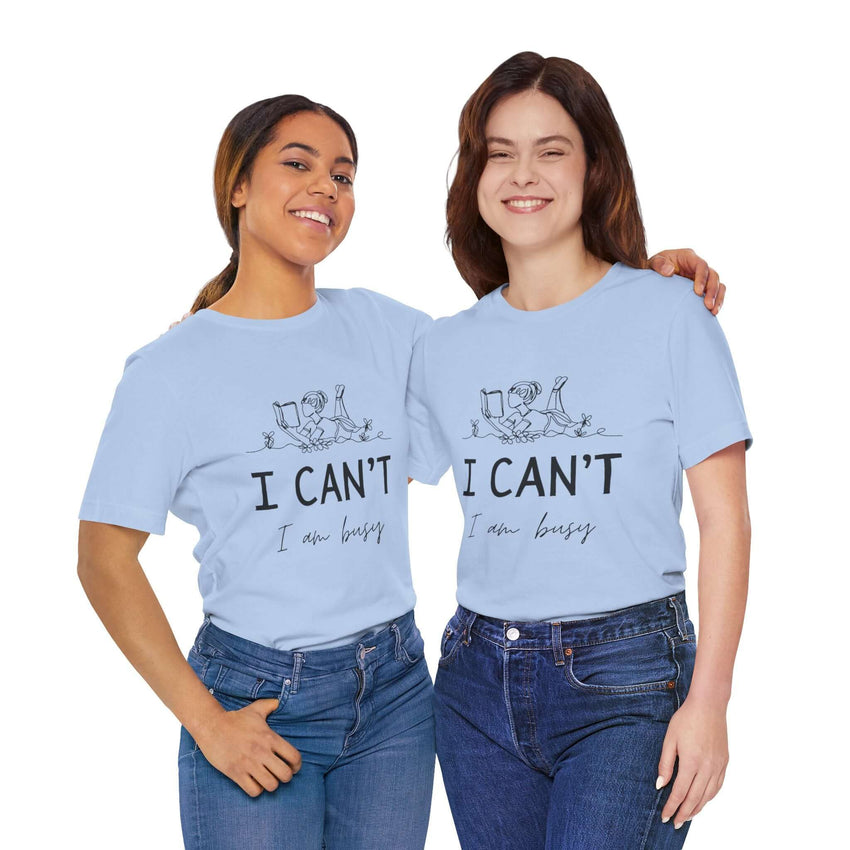 I Can’t, I’m Busy Unisex Jersey Short Sleeve TeeShow off your love for quiet moments with our I Can’t, I’m Busy Unisex Jersey Short Sleeve Tee. Perfect for book lovers and those who cherish their downtime, this tee features a playful illustration of a per