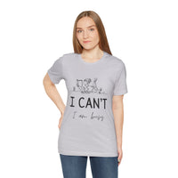 I Can’t, I’m Busy Unisex Jersey Short Sleeve TeeShow off your love for quiet moments with our I Can’t, I’m Busy Unisex Jersey Short Sleeve Tee. Perfect for book lovers and those who cherish their downtime, this tee features a playful illustration of a per